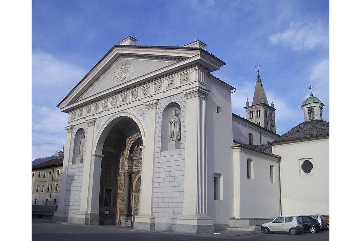 Facciata della Cattedrale di Aosta con dettagli architettonici romanici e affreschi storici.