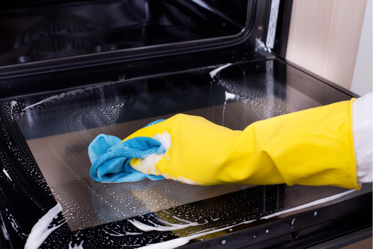 "Donna pulisce il forno con facilità, utilizzando un metodo rapido per risultati brillanti."